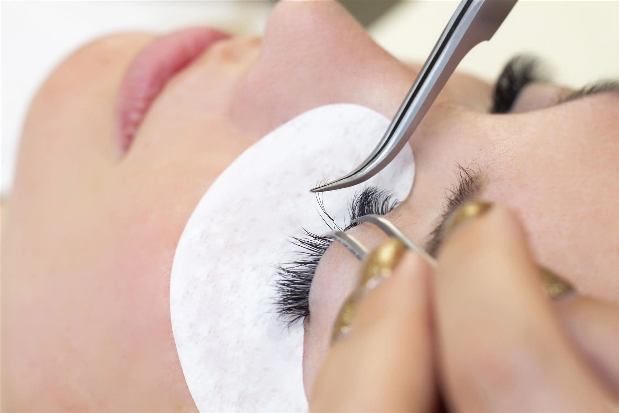 Lash extensions being applied one at a time under magnification
